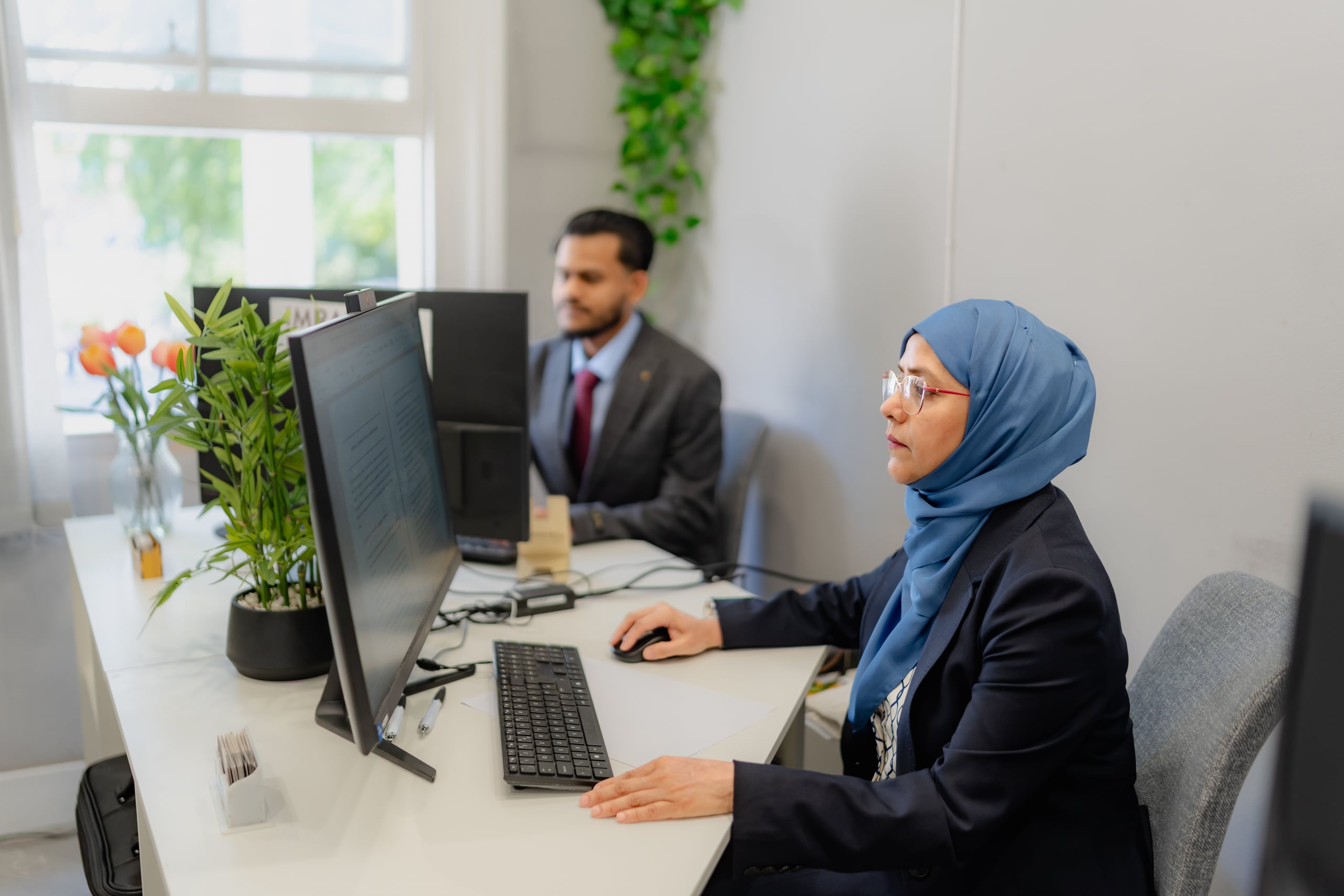 Two members of the Imran & Co team reviewing a client file at the office